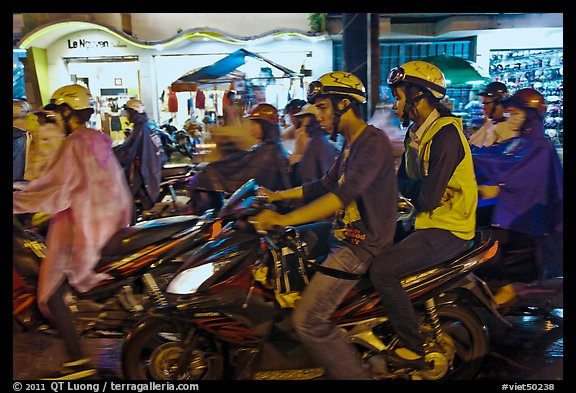 Street crowded with motorcycles on rainy night. Ho Chi Minh City, Vietnam (color)