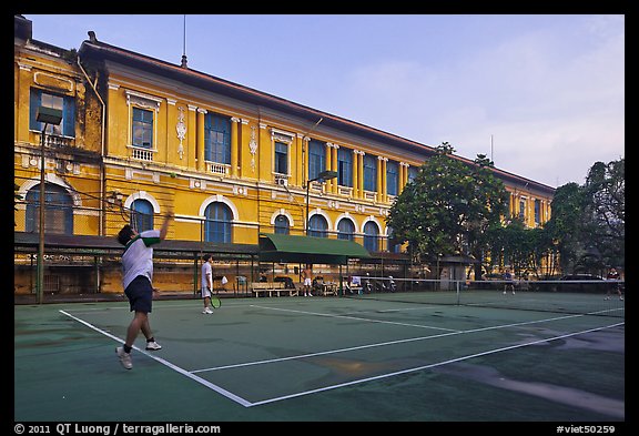 Men play tennis in front of colonial-area courthouse. Ho Chi Minh City, Vietnam