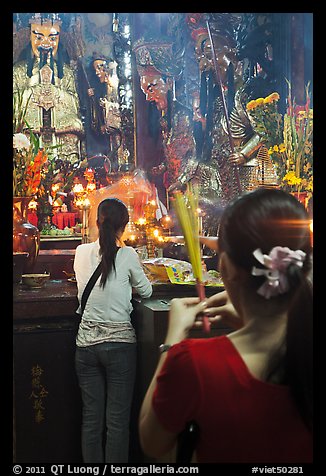 Women holding incense sticks, Phuoc Hai Tu pagoda, district 3. Ho Chi Minh City, Vietnam (color)