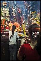 Women holding incense sticks, Phuoc Hai Tu pagoda, district 3. Ho Chi Minh City, Vietnam (color)