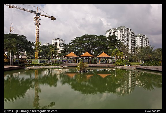 Reflecting pool, completed residential buildings, and crane, Phu My Hung, district 7. Ho Chi Minh City, Vietnam (color)