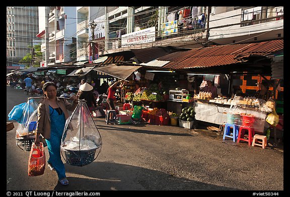 Woman carrying goods on street market. Ho Chi Minh City, Vietnam