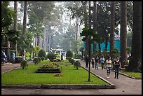 People strolling in alley below tall trees, Cong Vien Van Hoa Park. Ho Chi Minh City, Vietnam ( color)