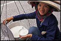 Woman smiling while handling bowl of soft tofu. Ho Chi Minh City, Vietnam ( color)