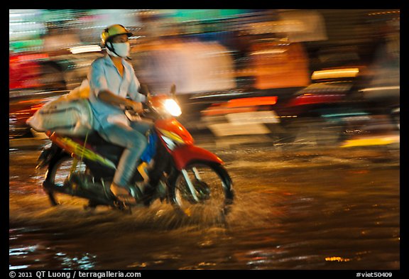 Motorcycle rider photographed with panning motion at night. Ho Chi Minh City, Vietnam (color)