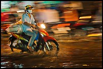 Motorcycle rider photographed with panning motion at night. Ho Chi Minh City, Vietnam ( color)