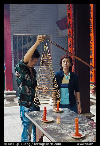 Man getting ready to hang incense coil, Thien Hau Pagoda, district 5. Cholon, District 5, Ho Chi Minh City, Vietnam