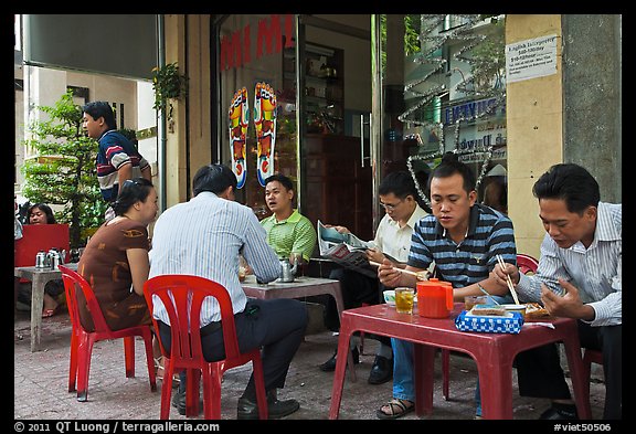 Men eating breakfast on the street. Ho Chi Minh City, Vietnam