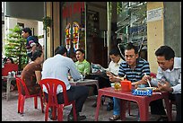 Men eating breakfast on the street. Ho Chi Minh City, Vietnam (color)