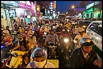 Street packed with motorcycles and vehicles at dusk. Ho Chi Minh City, Vietnam (color)