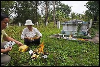 Women burning fake money as offering. Ben Tre, Vietnam ( color)