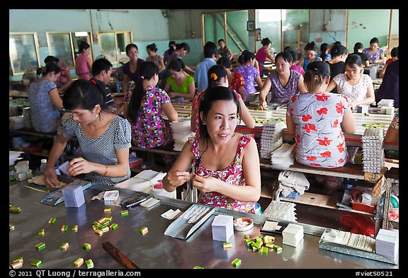 Workers wrapping up coconut candy. Ben Tre, Vietnam