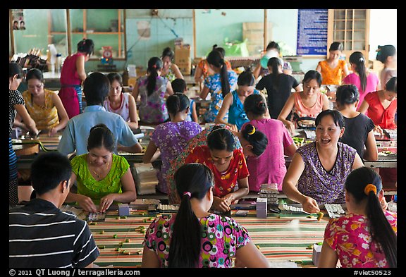 Women packing coconut candy in factory. Ben Tre, Vietnam (color)