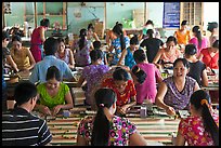 Women packing coconut candy in factory. Ben Tre, Vietnam ( color)