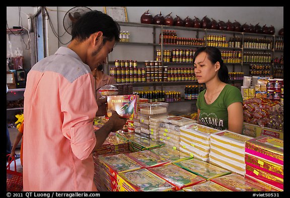 Customer buying box of coconut candy. Ben Tre, Vietnam (color)