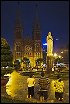 Family in prayer outside Notre-Dame Basilica at night. Ho Chi Minh City, Vietnam ( color)