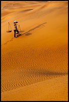 Woman with yoke baskets on sands. Mui Ne, Vietnam ( color)