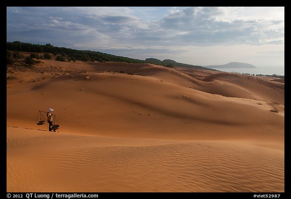 Coastal sand dunes with sea in distance and local woman. Mui Ne, Vietnam (color)