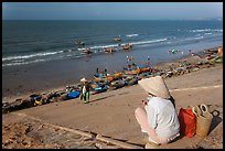 Woman on stairs overlooking beach with fishing boats. Mui Ne, Vietnam (color)