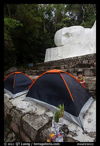 Child and tents set up below head of Buddha statue. Ta Cu Mountain, Vietnam