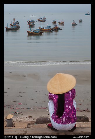 Woman with conical hat sitting above fishing fleet. Mui Ne, Vietnam (color)