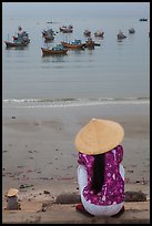 Woman with conical hat sitting above fishing fleet. Mui Ne, Vietnam ( color)