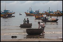 Fishermen on roundboats and fishing fleet. Mui Ne, Vietnam (color)