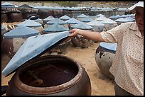 Woman examining vat of fish sauch. Mui Ne, Vietnam ( color)