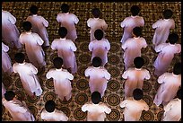 Worshippers dressed in white stand in rows in Cao Dai temple. Tay Ninh, Vietnam (color)