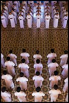 Men and women dressed in white stand in opposing rows in Cao Dai temple. Tay Ninh, Vietnam ( color)