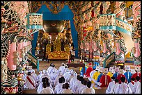 Dignitaries (in colored robes) and other followers praying at the Main hall, Cao Dai temple. Tay Ninh, Vietnam ( color)