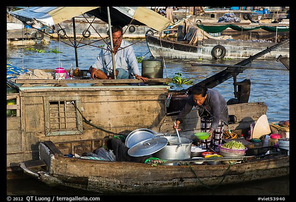 Woman serving food across boats, Cai Rang floating market. Can Tho, Vietnam (color)