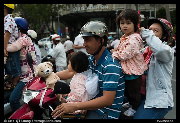 Family on motorbike watching musical performance. Ho Chi Minh City, Vietnam