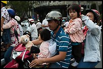 Family on motorbike watching musical performance. Ho Chi Minh City, Vietnam (color)