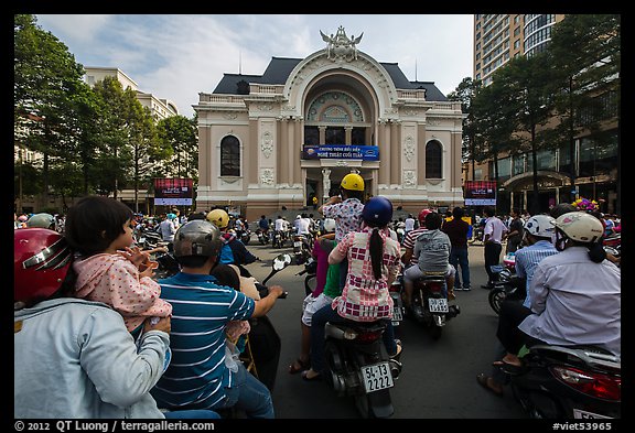 Families gather on motorbikes to watch performance in front of opera house. Ho Chi Minh City, Vietnam (color)