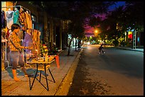 Woman tends to altar on street at dusk. Hoi An, Vietnam (color)