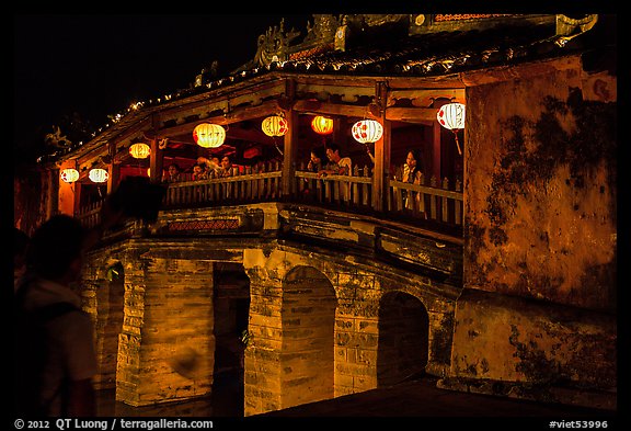 People enjoy Japanese Bridge lit solely by lanterns. Hoi An, Vietnam