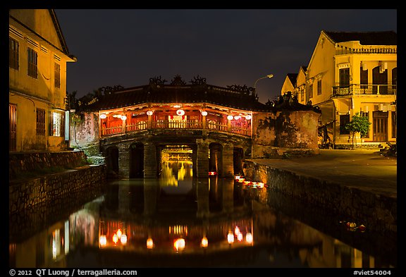 Covered Japanese Bridge reflected in canal by night. Hoi An, Vietnam