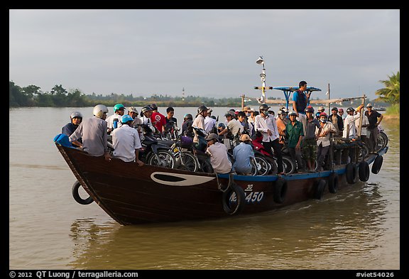 People crossing river on small ferry. Hoi An, Vietnam (color)