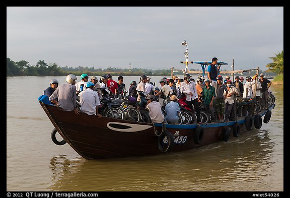 People crossing river on small ferry. Hoi An, Vietnam