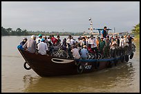 People crossing river on small ferry. Hoi An, Vietnam (color)