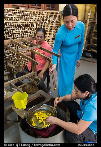 Workers demonstrate silkworm processing. Hoi An, Vietnam (color)