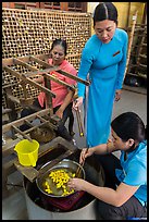 Workers demonstrate silkworm processing. Hoi An, Vietnam (color)