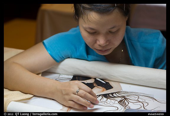 Woman working on a silk embroidery piece. Hoi An, Vietnam