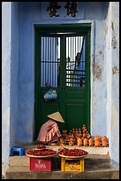 Ceramics vendor, blue temple door. Hoi An, Vietnam ( color)