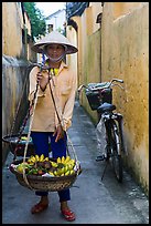 Fruit vendor carrying bananas. Hoi An, Vietnam (color)