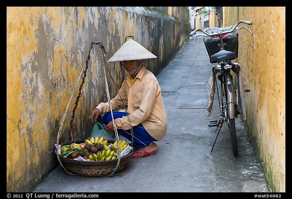 Fruit vendor in narrow alley. Hoi An, Vietnam (color)