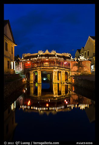 Illuminated Japanese covered bridge reflected in canal. Hoi An, Vietnam