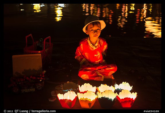 Boy selling candle lanterns at night. Hoi An, Vietnam