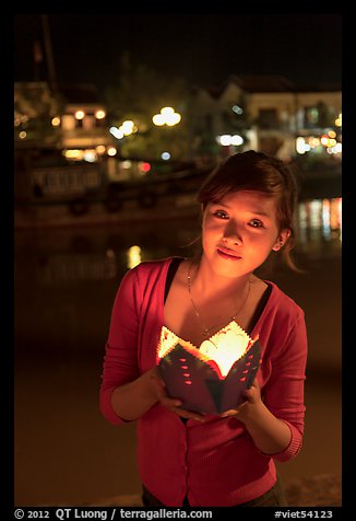 Woman holding candle box at night. Hoi An, Vietnam